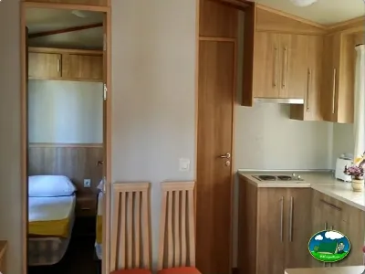 Mobil-home interior con cocina y dormitorio del Camping Parque Tropical, Estepona (Málaga)