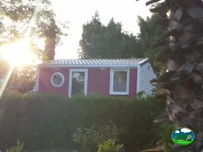 Cabaña roja en parcela arbolada del Camping Parque Tropical, Estepona (Málaga)