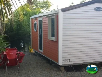 Mobil-home con terraza y sillas rojas del Camping Parque Tropical, Estepona (Málaga)