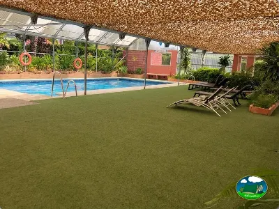 Piscina climatizada cubierta con tumbonas y zona verde del Camping Parque Tropical, Estepona (Málaga)
