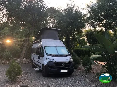 Mobil-home en parcela arbolada al atardecer del Camping Parque Tropical, Estepona (Málaga)