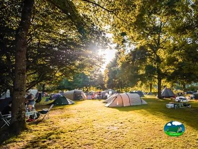 Parcela con tienda de acampada bajo árboles del Camping Eichholz, Wabern (Berna)
