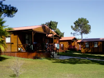 Bungalow de madera con terraza y vistas al entorno arbolado del Camping Lagoa de Santo Andre, Santo Andre (Setúbal)