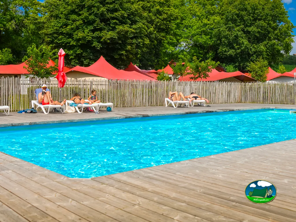 piscina con tumbonas junto a valla