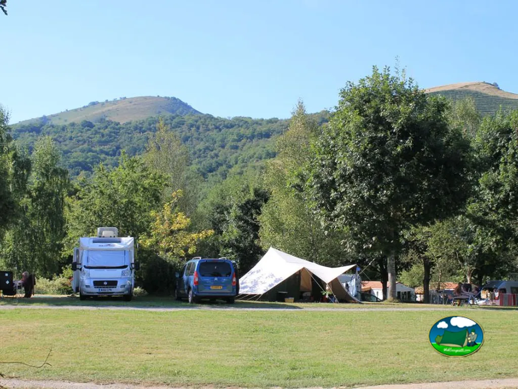 autocaravana y tienda junto a colinas