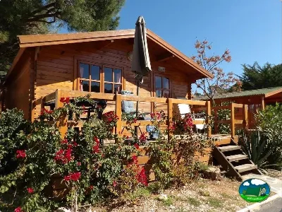 Bungalow de madera con terraza y flores del Camping Cabopino, Marbella (Málaga)