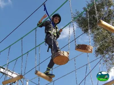 Parque infantil circuito aventura con niño en tirolesa del Camping Cabopino, Marbella (Málaga)