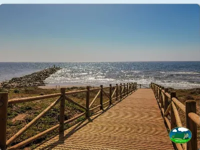 Pasarela de madera junto al mar con vistas a playa del Camping Cabopino, Marbella (Málaga)