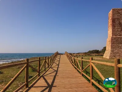 Pasarela de madera junto al mar con vistas a la playa del Camping Cabopino, Marbella (Málaga)