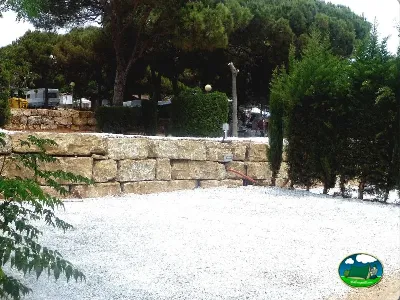 Parcela con muro de piedra y arboleda del Camping Cabopino, Marbella (Málaga)