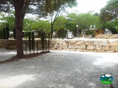 Parcela con árboles y muros de piedra del Camping Cabopino, Marbella (Málaga)
