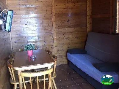 Cabaña interior con cama y mesa comedor del Camping Cabopino, Marbella (Málaga)