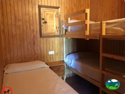 Cabaña interior con cama y literas de madera del Camping Cabopino, Marbella (Málaga)