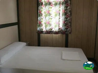 Mobil-home interior con cama y cortinas del Camping Cabopino, Marbella (Málaga)
