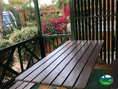 Parcela con terraza de madera y flores del Camping Cabopino, Marbella (Málaga)