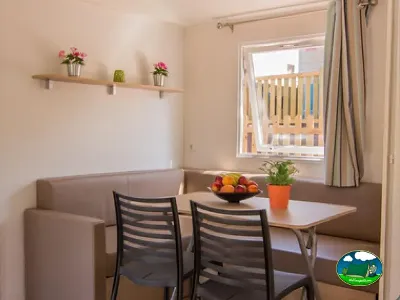 Bungalow interior con zona de comedor y ventanas del Camping Cabopino, Marbella (Málaga)