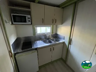 Cocina de mobil-home con microondas y fregadero del Camping Cabopino, Marbella (Málaga)