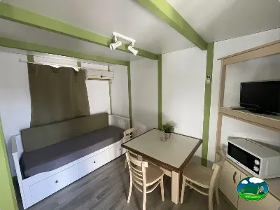 Mobil-home con cama dosel y zona de comedor del Camping Cabopino, Marbella (Málaga)