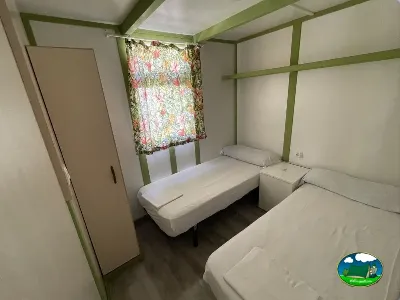 Glamping interior con tres camas y armario del Camping Cabopino, Marbella (Málaga)