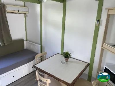 Mobil-home interior con cama y zona de comedor del Camping Cabopino, Marbella (Málaga)