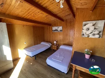 Cabaña interior con dos camas y escritorio de madera del Camping Cabopino, Marbella (Málaga)