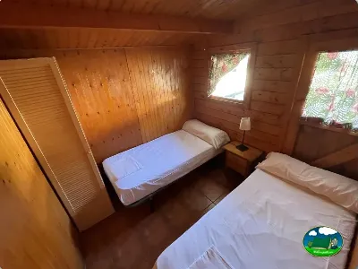 Cabaña de madera interior con dos camas del Camping Cabopino, Marbella (Málaga)
