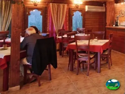 Restaurante interior con mesas y sillas de madera del Camping Cabopino, Marbella (Málaga)