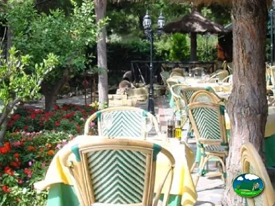 Restaurante con terraza arbolada y flores del Camping Cabopino, Marbella (Málaga)