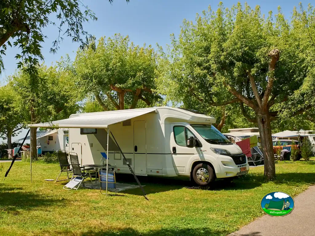 autocaravana con toldo bajo árboles