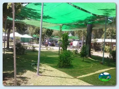 Parcela con toldo verde y césped del Camping Valle Niza Playa, Benajarafe (Málaga)