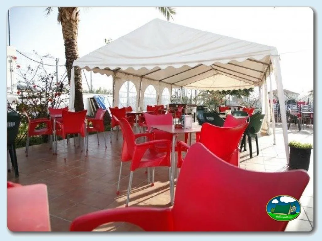 Restaurante bar con terraza cubierta y sillas rojas del Camping Valle Niza Playa, Benajarafe (Málaga)