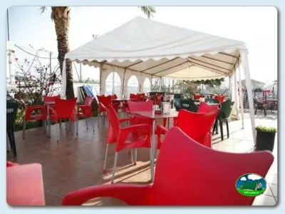 Restaurante bar con terraza cubierta y sillas rojas del Camping Valle Niza Playa, Benajarafe (Málaga)
