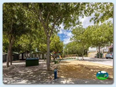 Parcela con mobil-homes y parque infantil bajo árboles del Camping El Pino, Urbanización Torrox Park (Málaga)