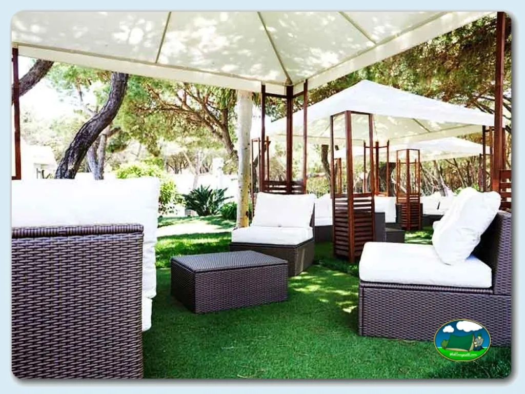 Zona de relax con sombrillas y tumbonas bajo árboles del Camping Orbitur Guincho, Cascais (Lisboa)
