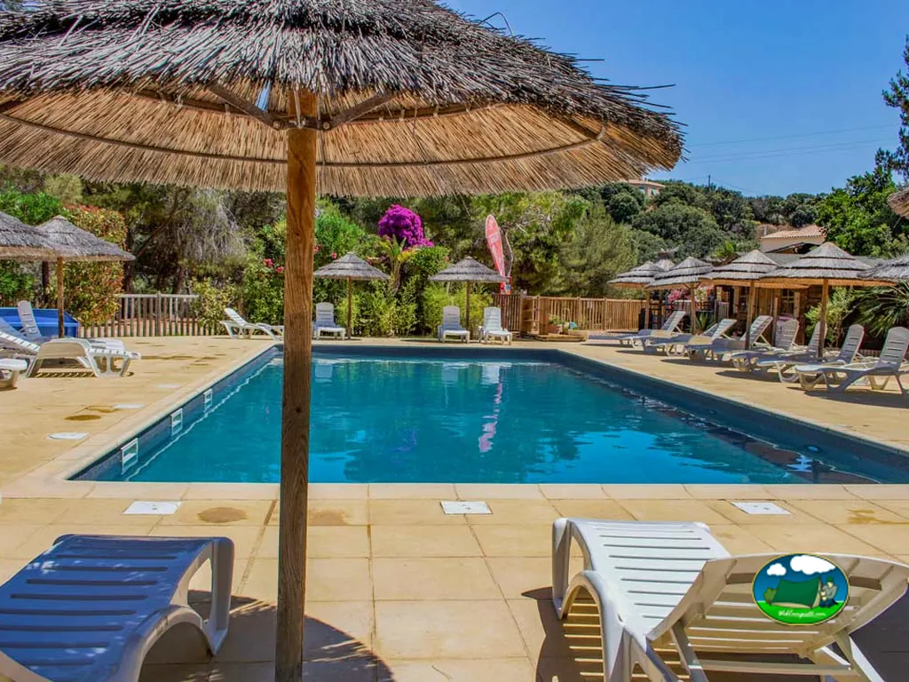 Piscina con sombrillas de paja