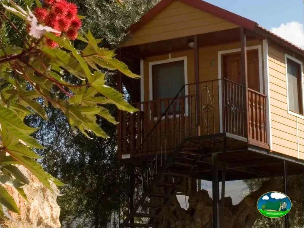 Bungalow elevado con terraza y flores rojas del Camping Orgiva, Órgiva (Granada)