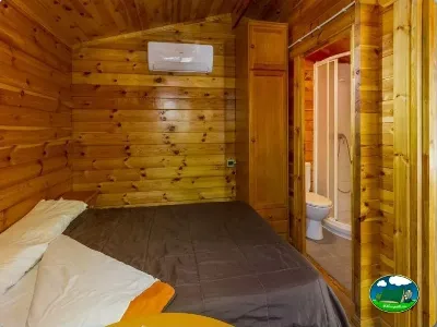 Cabaña de madera con cama doble y baño privado del Camping Las Lomas, Güejar Sierra (Granada)