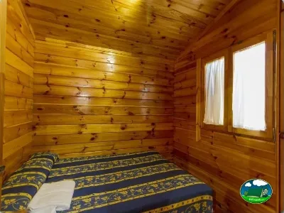Cabaña de madera con cama doble del Camping Las Lomas, Güejar Sierra (Granada)