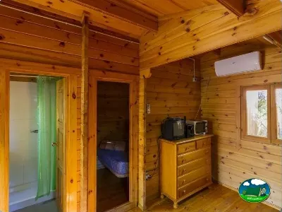Cabaña interior con dormitorio y equipamiento del Camping Las Lomas, Güejar Sierra (Granada)