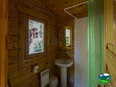 Baño interior cabaña de madera con ventana del Camping Las Lomas, Güejar Sierra (Granada)