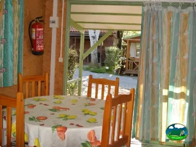 Cabaña interior con mesa y sillas de madera del Camping Las Lomas, Güejar Sierra (Granada)