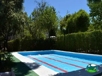 Piscina con carril de nado entre árboles del Camping Las Lomas, Güejar Sierra (Granada)