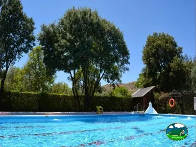 Piscina con vistas a la montaña y árboles del Camping Las Lomas, Güejar Sierra (Granada)