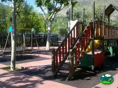 Parque infantil con tobogán y montaña de fondo del Camping Las Lomas, Güejar Sierra (Granada)