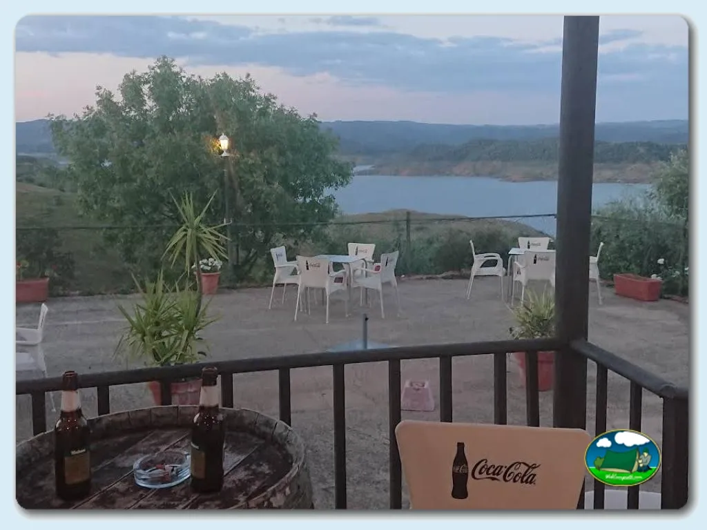 Lago con vistas desde terraza, mesas y sillas del Camping La Breña, Almodovar (Córdoba)