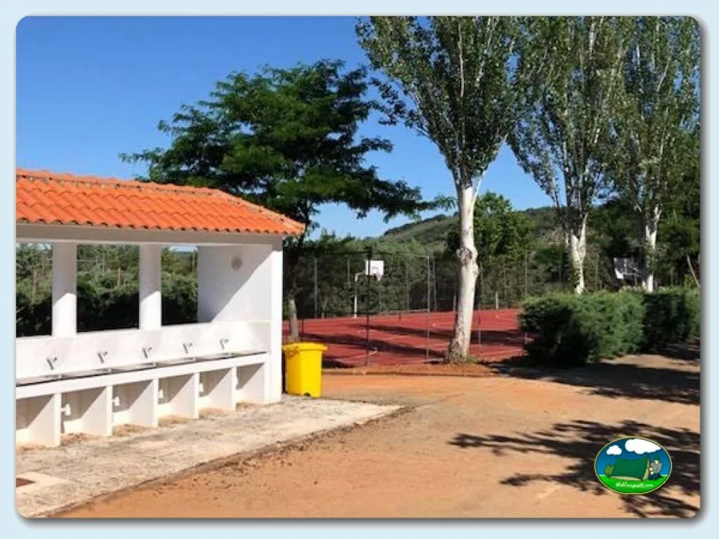 Aseos y pista de tenis en entorno de montaña del Camping Los Ibores, Castañar de Ibor (Cáceres)