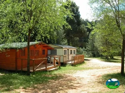 Mobil-home entre árboles en parcela arbolada del Camping Puente de las Herrerías, Cazorla (Jaén)