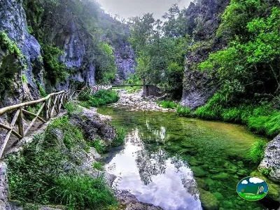 Río entre montañas con puente de madera del Camping Puente de las Herrerías, Cazorla (Jaén)