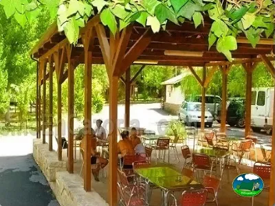 Restaurante con pérgola de madera y sombra natural del Camping Puente de las Herrerías, Cazorla (Jaén)