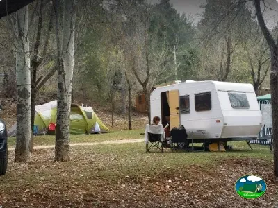 Caravana en parcela arbolada con tienda de campaña del Camping Puente de las Herrerías, Cazorla (Jaén)